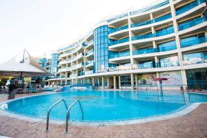 a large swimming pool in front of a building at Marina Holiday Club&SPA Apartment in Pomorie