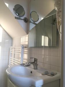 y baño con lavabo y espejo. en Apartments Katrca Ljubljana en Liubliana
