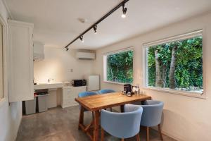 una cucina e una sala da pranzo con tavolo e sedie in legno di ADAN RESORT 縁 - En - a Motobu