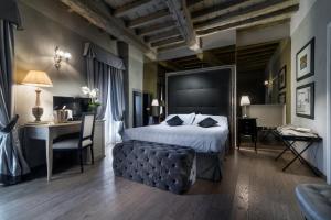 a bedroom with a large bed and a desk and a desk at Villa Casagrande Resort e SPA in Figline Valdarno