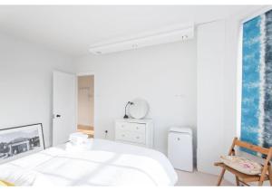 - une chambre blanche avec un lit et une fenêtre dans l'établissement JOIVY Bright 1 bed flat, next to Hyde Park, à Londres