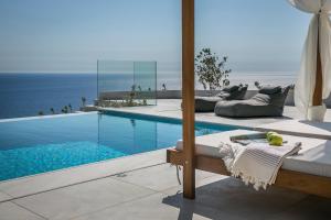 - une piscine avec un lit et une vue sur l'océan dans l'établissement Oikos Boutique Residences Private Estate, à Plateies