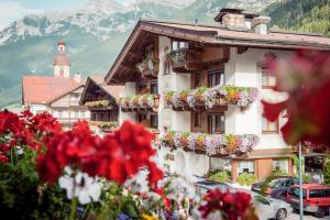 un bâtiment avec des boîtes de fleurs sur son côté dans l'établissement Hotel Angelika, à Neustift im Stubaital