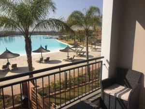 a balcony with a view of a pool and palm trees at The Blyde in Pretoria