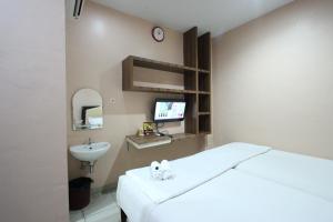 1 dormitorio con 1 cama, lavamanos y TV en O2 Residence, en Medan