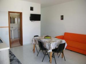 アルカモ・マリーナにあるCasa Rachele ad Alcamo Marinaのリビングルーム(テーブル、椅子、ソファ付)