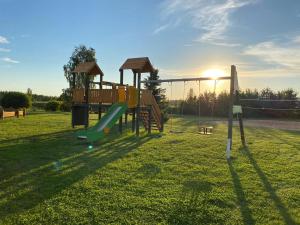 a playground with a slide in the grass at Atpūtas māja STIRNA in Zilāni