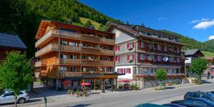 un grupo de edificios en una calle con una montaña en Kienle - das Kräuterhotel, en Balderschwang
