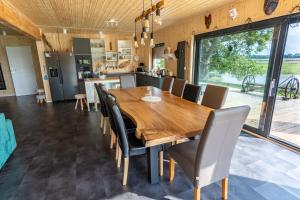 een keuken en eetkamer met een houten tafel en stoelen bij Houses with a View#Sauna#Jaccuzi in Gozdowice
