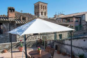 - une table avec un parasol blanc sur la terrasse dans l'établissement La Terrazza sul Borgo, à Narni