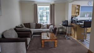 a living room with a couch and a table at Glennydd House in Llangefni