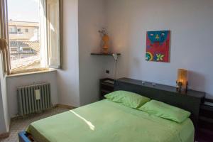 Un dormitorio con una cama verde y una ventana en La Terrazza sul Borgo, en Narni