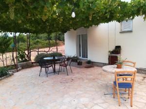 a patio with chairs and a table and a building at Apartman Rosa in Skradin