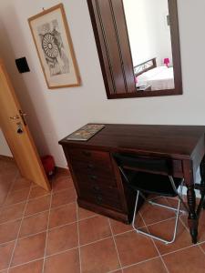 a wooden desk with a mirror on a wall at podere la starza in Laureana Cilento