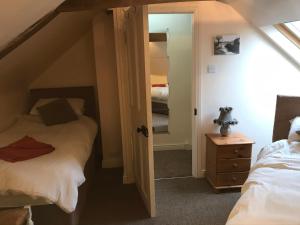 - une chambre mansardée avec 2 lits et un miroir dans l'établissement Bottesford Cottage - Leicestershire, à Bottesford