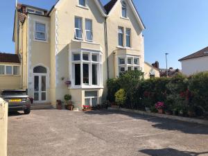 a white house with a car parked in front of it at Esk Vale Guest House in Portsmouth