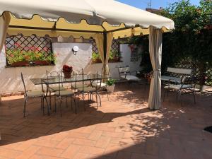 een patio met een tafel en stoelen onder een tent bij La terrazza di Elena in Abbadia San Salvatore