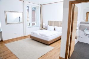 a white bedroom with a bed and a sink at Lothringer Hof in Saarlouis