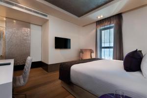 a hotel room with a bed and a tv at Royal Beach Hotel Tel Aviv by Isrotel Exclusive in Tel Aviv