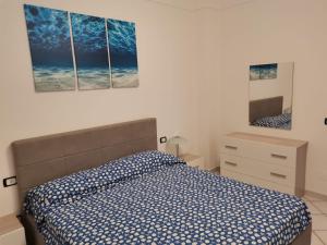 ein Schlafzimmer mit einem Bett und zwei Gemälden an der Wand in der Unterkunft A CASA in Ischia