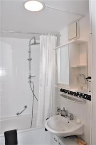 a white bathroom with a shower and a sink at GardenOasisBerlinAirport in Schönefeld