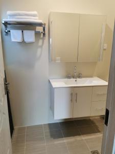 a white bathroom with a sink and a mirror at Sunshine Gardens Bourke Resort in Bourke