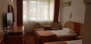 a hotel room with two beds and a window at GRAND HOTEL CEAHLAU in Piatra Neamţ