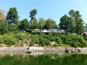 a house on a hill next to a body of water at SK Delfín Jesenice Cheb in Cheb