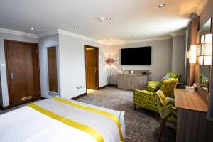 a hotel room with a bed and a flat screen tv at Best Western Plus Pastures Hotel in Doncaster