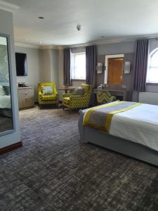 Habitación de hotel con cama, escritorio y sillas en Best Western Plus Pastures Hotel en Doncaster