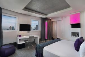 a bedroom with a bed and a desk and a tv at Royal Beach Hotel Tel Aviv by Isrotel Exclusive in Tel Aviv