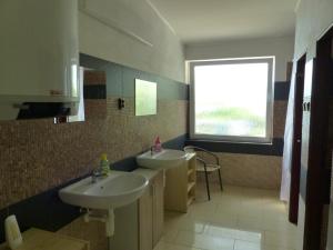 a bathroom with two sinks and a window at SK Delfín Jesenice Cheb in Cheb