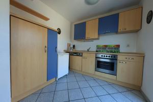 a kitchen with wooden cabinets and a stove top oven at Ferienwohnung Altötting in Unterneukirchen