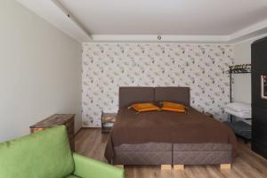 a bedroom with a bed and a green couch at Lapmanni Holiday Home in Haapsalu