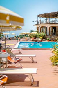a resort with a pool and chairs and a building at Hotel Villa Giuseppina in Scala