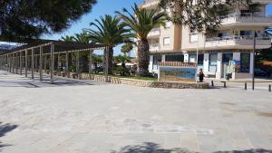a large plaza with palm trees in front of a building at Moraira Beach in Moraira