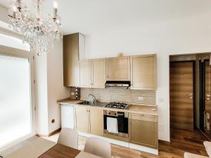 une cuisine avec des placards en bois et un lustre dans l'établissement Appartamento Stefano Laudi, à Porto SantʼElpidio