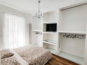ポルト・サンテルピーディオにあるAppartamento Stefano Laudiの白いベッドルーム(ベッド1台、テレビ付)