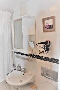 a white bathroom with a sink and a mirror at GardenOasisBerlinAirport in Schönefeld