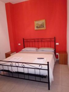 ein Schlafzimmer mit einer roten Wand und einem Bett in der Unterkunft kola age in Peschiera del Garda