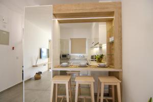 a kitchen with wooden stools and a counter with a sink at Phaedrus Living Seaview Luxury Flat Limnaria 153 in Paphos City
