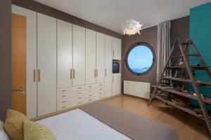a bedroom with white cabinets and a round window at Ixian Hilltop Villa in Ialysos +42 photos