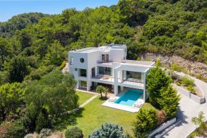 an aerial view of a white house with a swimming pool at Ixian Hilltop Villa in Ialysos