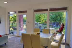ein Esszimmer mit Tisch und Stühlen sowie Glasschiebetüren in der Unterkunft Apartment Vila Tara in Bihać