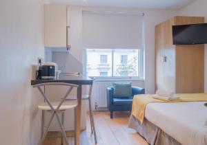 Mały pokój z łóżkiem, stołem i krzesłem w obiekcie Hyde Park Executive Apartments w Londynie