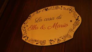 a sign on a wooden wall with the words ahala aloha and marmi at La casa di Elba e Mario in Porto Santo Stefano