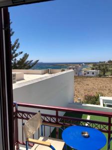 埃伊歐索斯蒂斯的住宿－Akrogiali Hotel，阳台配有桌椅,享有海滩美景。