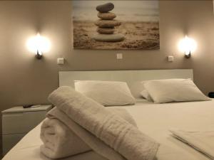 a bedroom with a bed with a pile of rocks on it at Akrogiali Hotel in Agios Sostis