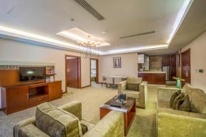 a living room with two couches and a television at Grand Plaza Hotel - Dhabab Riyadh in Riyadh