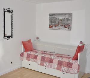un divano bianco con cuscini rossi in una stanza di GardenOasisBerlinAirport a Schönefeld